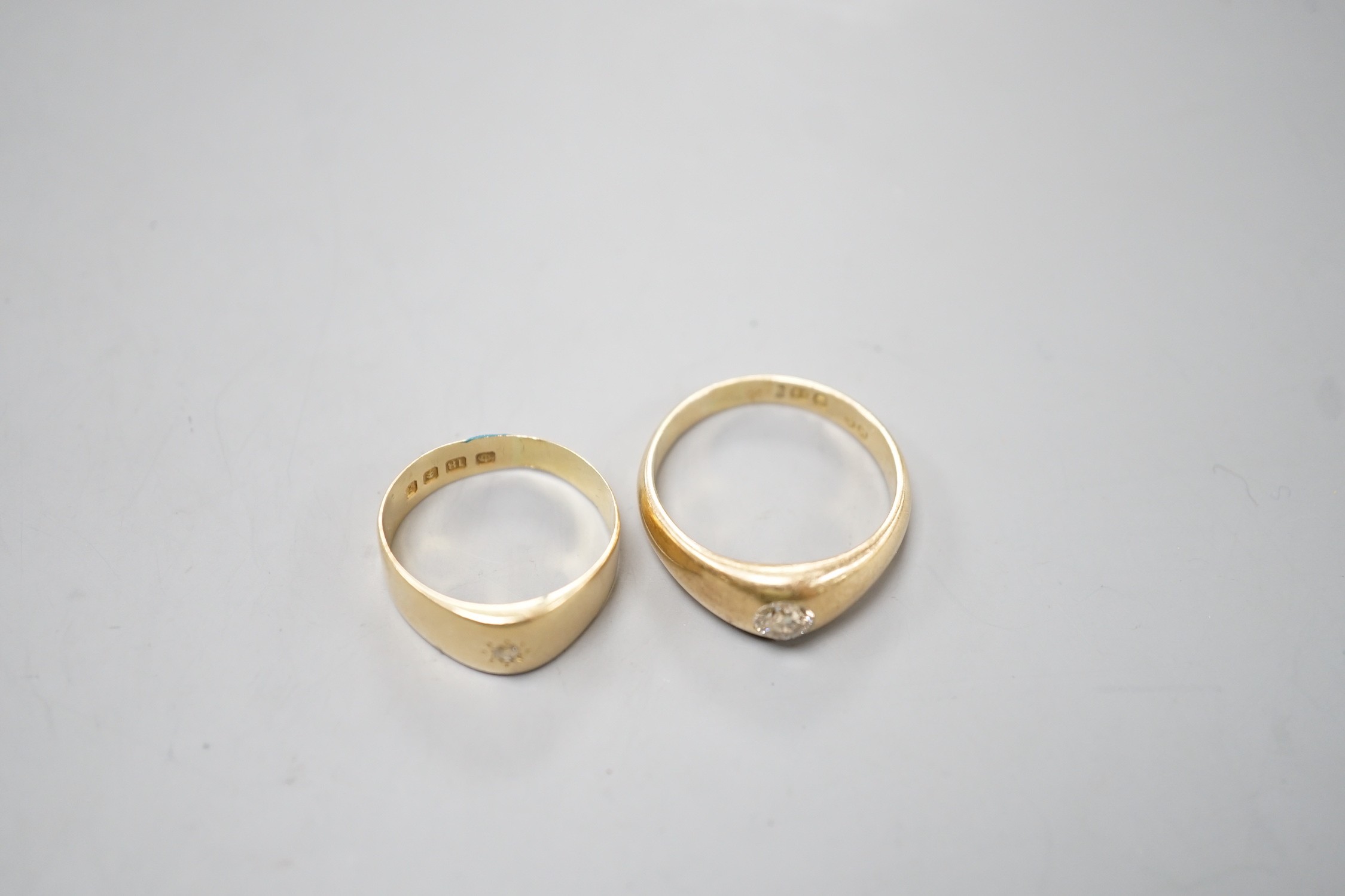 Two 18ct gold and gypsy set solitaire diamond rings, largest size T/U, gross weight 11.3 grams.